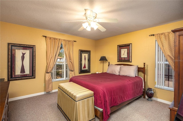 bedroom with ceiling fan, carpet floors, and a textured ceiling