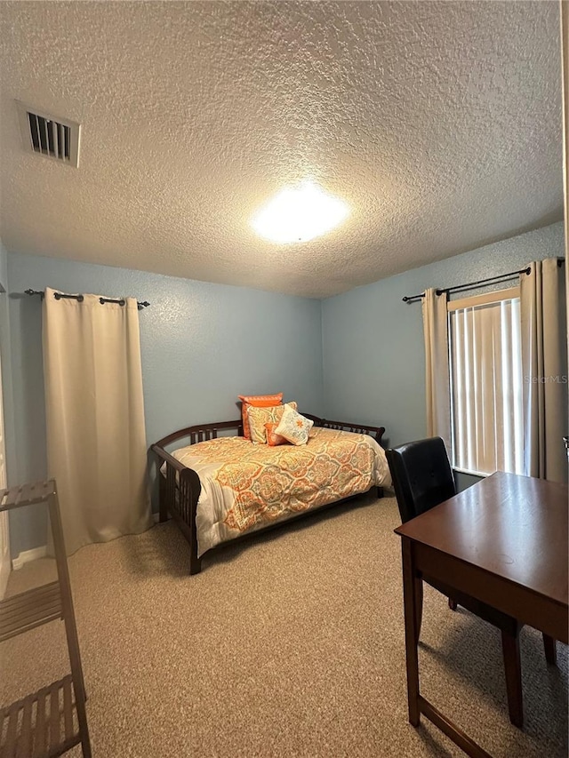 carpeted bedroom with a textured ceiling and visible vents