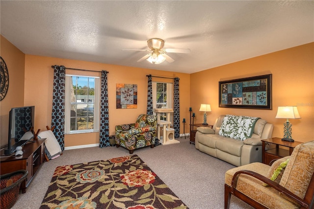 living room with a textured ceiling, carpet flooring, a ceiling fan, and baseboards