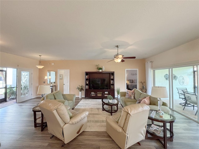 living room with hardwood / wood-style flooring, a wealth of natural light, a textured ceiling, and ceiling fan