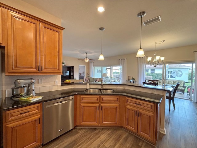 kitchen featuring sink, wood-type flooring, dishwasher, kitchen peninsula, and pendant lighting