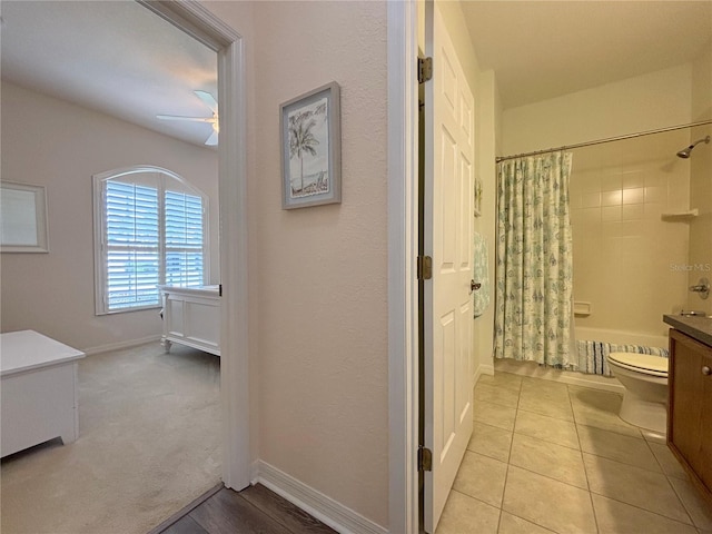 full bathroom with tile patterned flooring, vanity, ceiling fan, toilet, and shower / bath combo with shower curtain