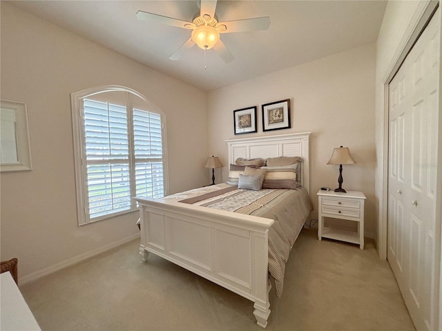 bedroom featuring light carpet, a closet, and ceiling fan