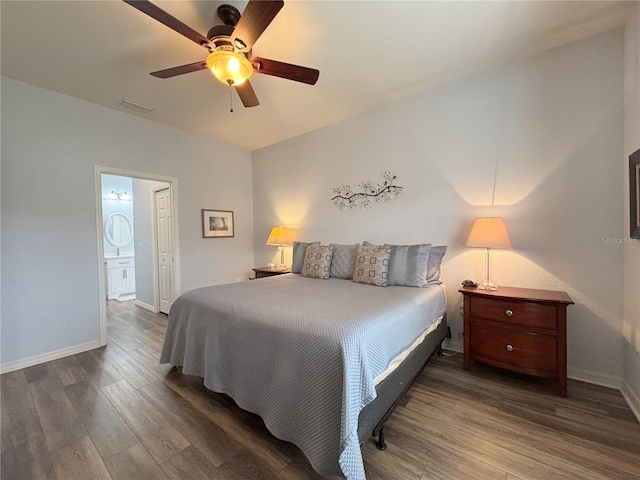 bedroom featuring dark hardwood / wood-style flooring, ceiling fan, and ensuite bathroom