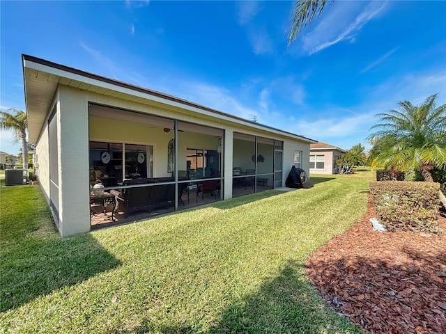 back of property with a yard, a sunroom, and central air condition unit