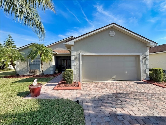 ranch-style home featuring a garage and a front lawn