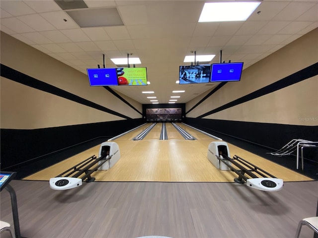 playroom with a drop ceiling, hardwood / wood-style flooring, and a bowling alley