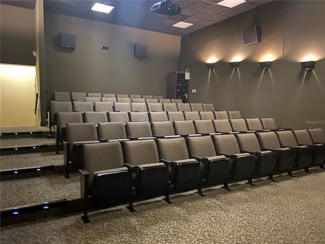 cinema featuring a paneled ceiling and carpet flooring