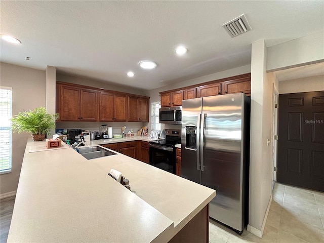 kitchen with sink, plenty of natural light, stainless steel appliances, and kitchen peninsula