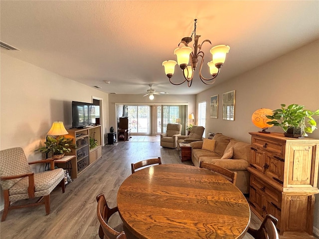 dining area featuring hardwood / wood-style floors and ceiling fan with notable chandelier