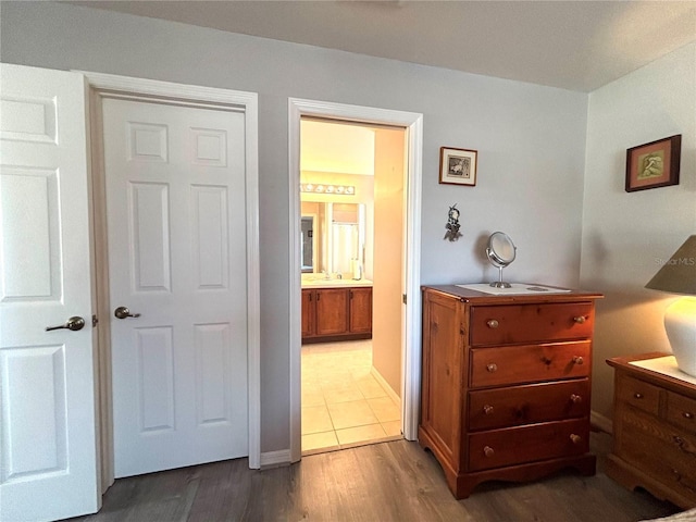 bedroom featuring hardwood / wood-style flooring and ensuite bath