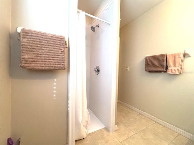 bathroom with curtained shower and tile patterned floors