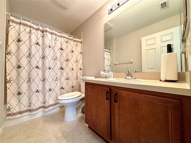 bathroom featuring vanity, tile patterned flooring, toilet, and walk in shower