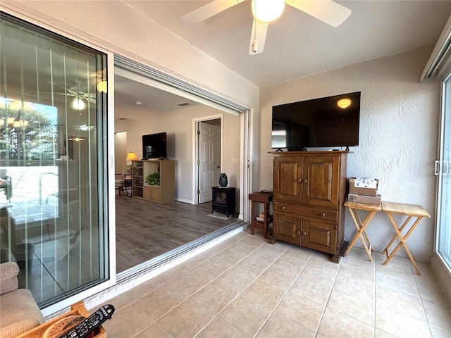 interior space featuring light tile patterned floors and ceiling fan