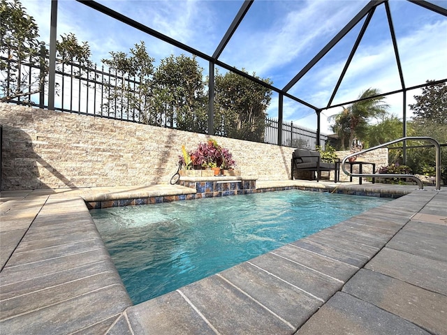 view of pool featuring pool water feature and glass enclosure