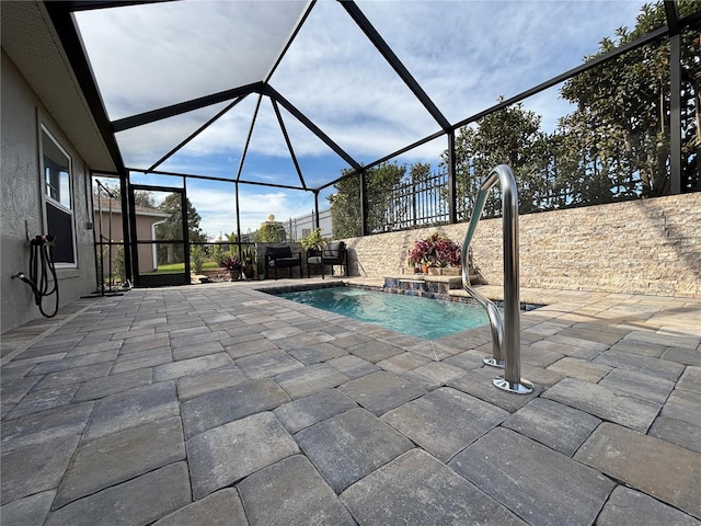 view of swimming pool featuring a lanai, pool water feature, and a patio area