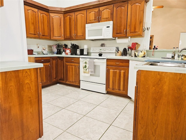 kitchen with sink, light tile patterned floors, and white appliances