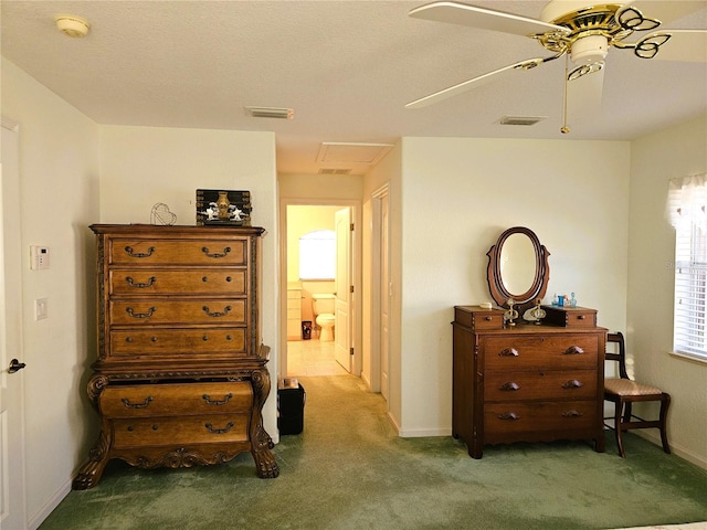 carpeted bedroom with ensuite bath and ceiling fan