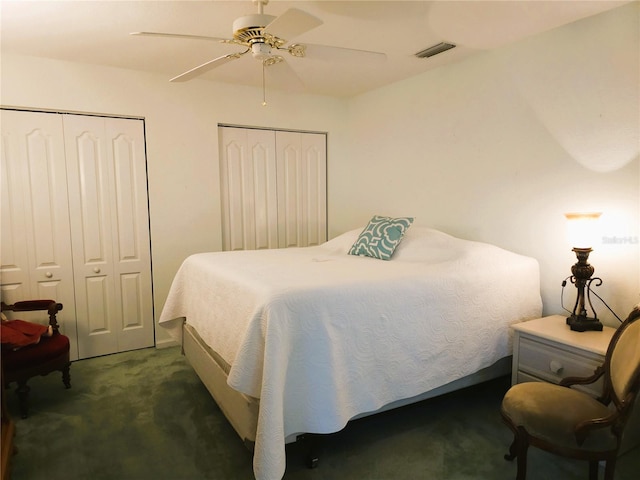 bedroom with multiple closets, ceiling fan, and dark colored carpet