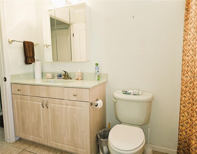 bathroom with vanity, tile patterned flooring, and toilet