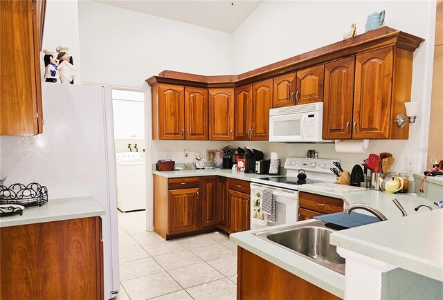 kitchen with white appliances, washer / clothes dryer, sink, and light tile patterned floors