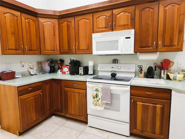 kitchen with white appliances and light tile patterned floors