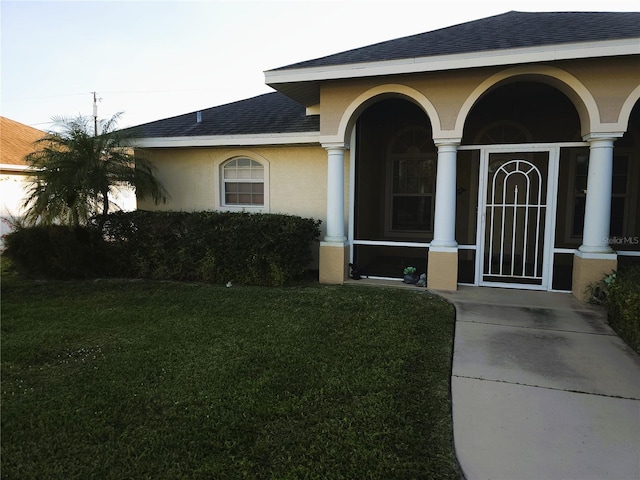 doorway to property featuring a lawn