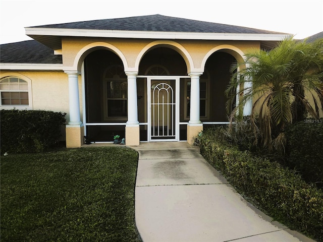 view of exterior entry with a lawn