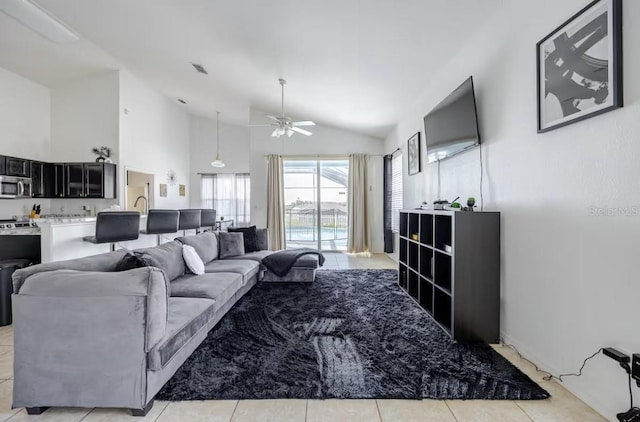 tiled living room featuring ceiling fan and high vaulted ceiling