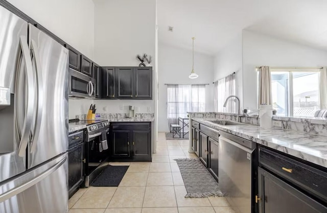 kitchen with sink, light stone counters, light tile patterned floors, pendant lighting, and stainless steel appliances