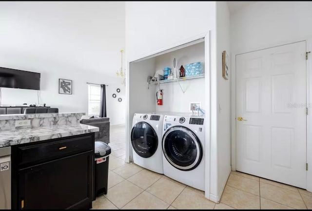 clothes washing area with light tile patterned flooring and washer and clothes dryer