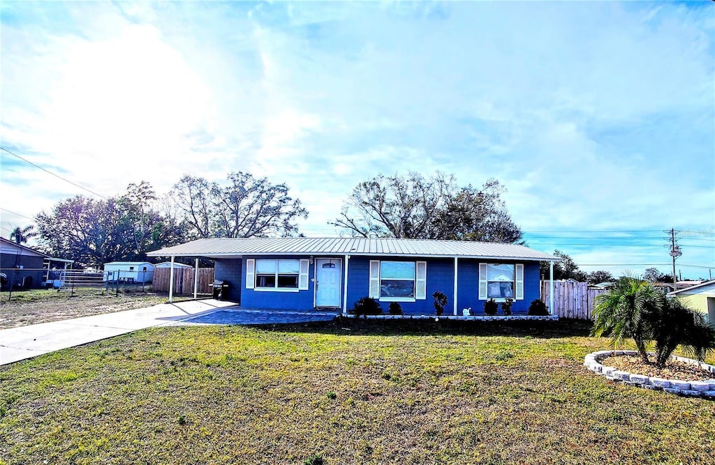 ranch-style house featuring a carport and a front yard