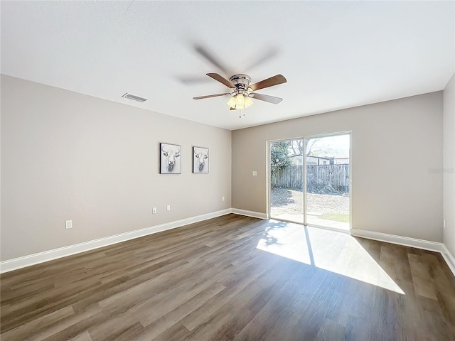 unfurnished room featuring dark wood-type flooring and ceiling fan