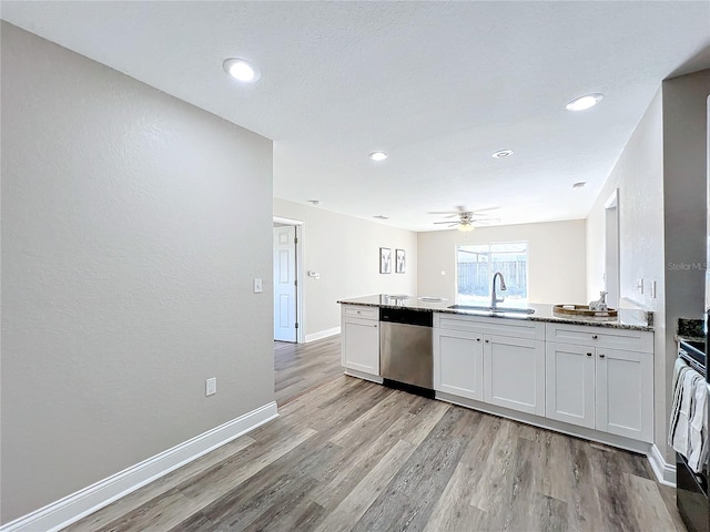 kitchen with white cabinetry, sink, stainless steel dishwasher, ceiling fan, and light hardwood / wood-style flooring