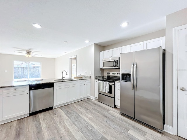 kitchen with stainless steel appliances, sink, and white cabinets