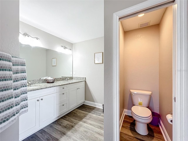 bathroom with vanity, hardwood / wood-style floors, and toilet