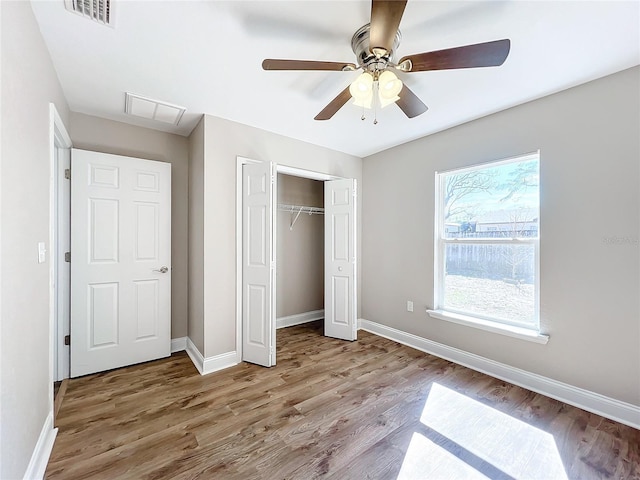 unfurnished bedroom with light hardwood / wood-style flooring, ceiling fan, and a closet