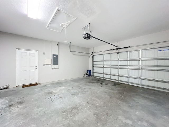 garage with a garage door opener and electric panel