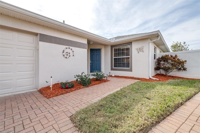 entrance to property with a garage and a yard