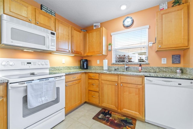 kitchen featuring sink, a textured ceiling, light tile patterned floors, white appliances, and light stone countertops