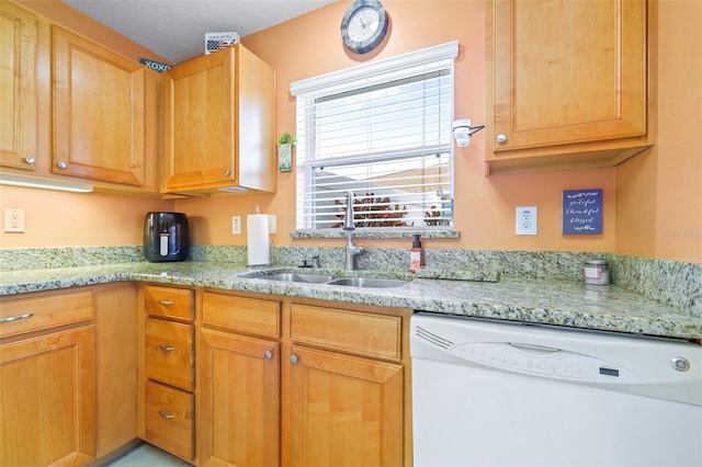 kitchen with light stone counters, white dishwasher, and sink