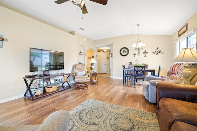 living room featuring lofted ceiling, ceiling fan with notable chandelier, and light wood-type flooring