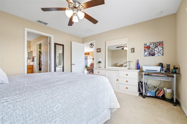 carpeted bedroom with ensuite bath and ceiling fan