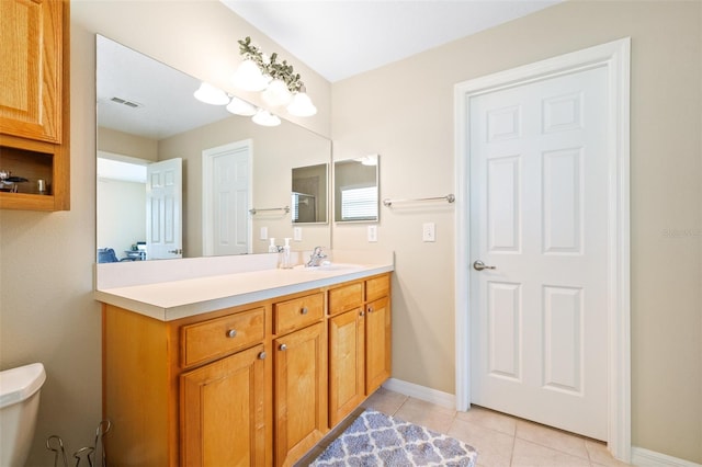 bathroom featuring tile patterned flooring, vanity, and toilet