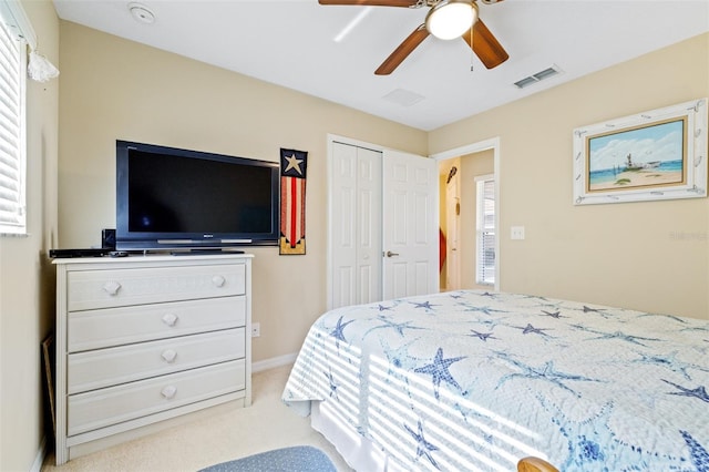 carpeted bedroom with ceiling fan and a closet