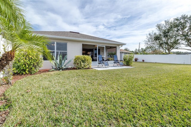 rear view of property featuring a yard and a patio area