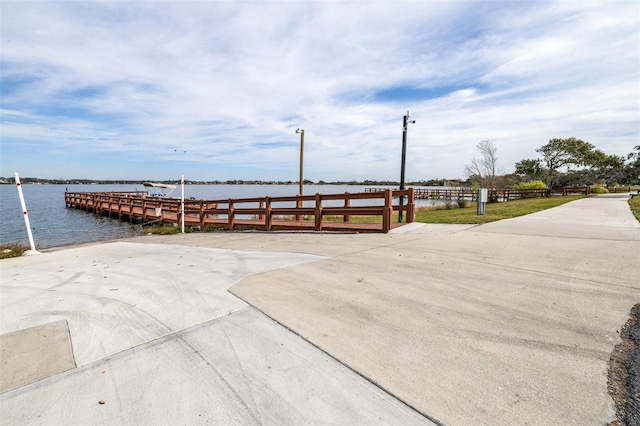 surrounding community featuring a water view and a dock