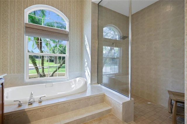 bathroom with independent shower and bath and tile patterned flooring