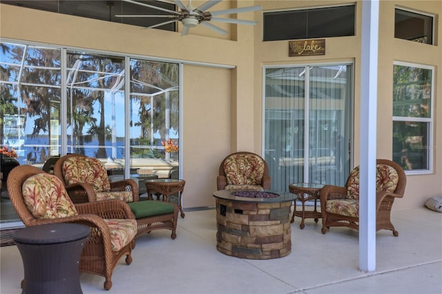 view of patio featuring a lanai, ceiling fan, and an outdoor fire pit