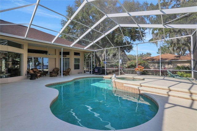 view of swimming pool with an in ground hot tub, a lanai, and a patio area